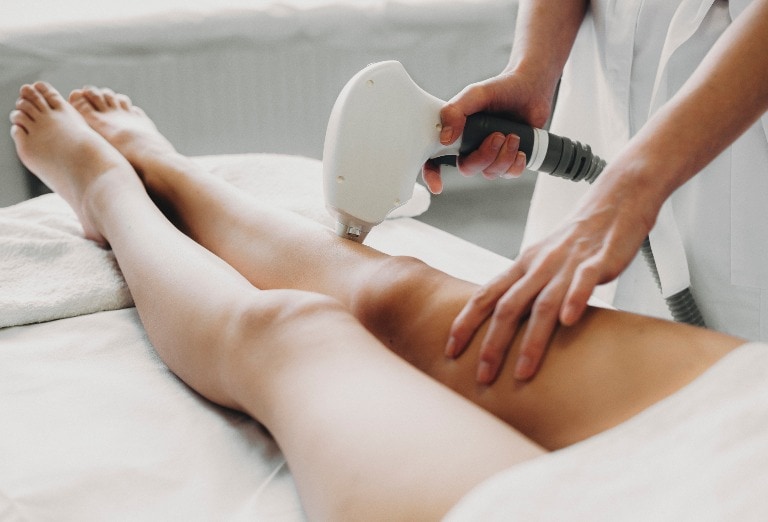 Cosmetologist doing laser epilation to her client. Beautiful wom
